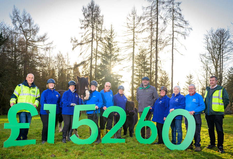 Members of Shiresmill Therapy Riding Centre holding up oversized numbers displaying, &#39;&#163;15260&#39; donated to the charity.